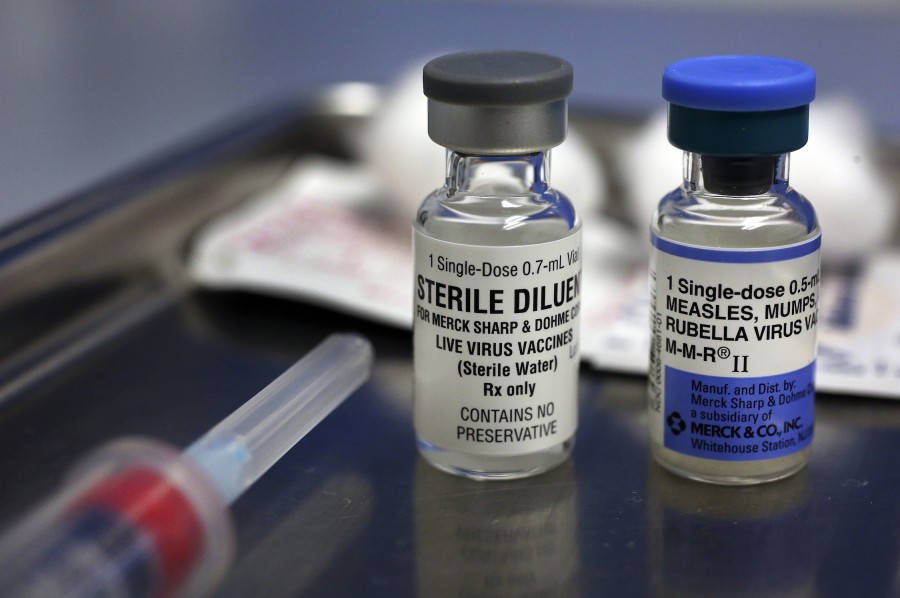 A vial containing the MMR vaccine, right, and another vial containing the diluent used to mix the vaccine, sit on a tray before being loaded into a syringe at the Medical Arts Pediatric Med Group in Los Angeles on Feb. 6, 2015. (Mel Melcon/Los Angeles Times/TNS)
