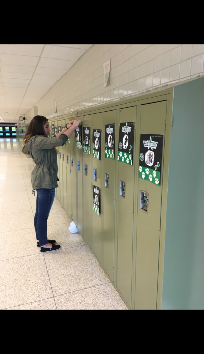 Sophomore Gabbie Vogg hangs some of the hundreds of posters that Cats Cabinet worked really hard on. The students in other sports teams and clubs seem to appreciate them very much. 