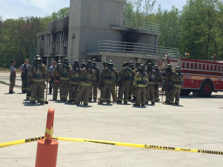 Training firemen get ready to enter a burning building. 