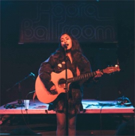 Tindel performing one of her original songs at The Agora.