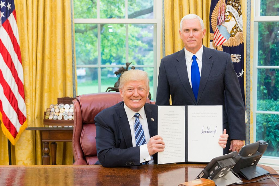 President Trump, joined by Vice President Mike Pence, displays a signed executive action order. 
