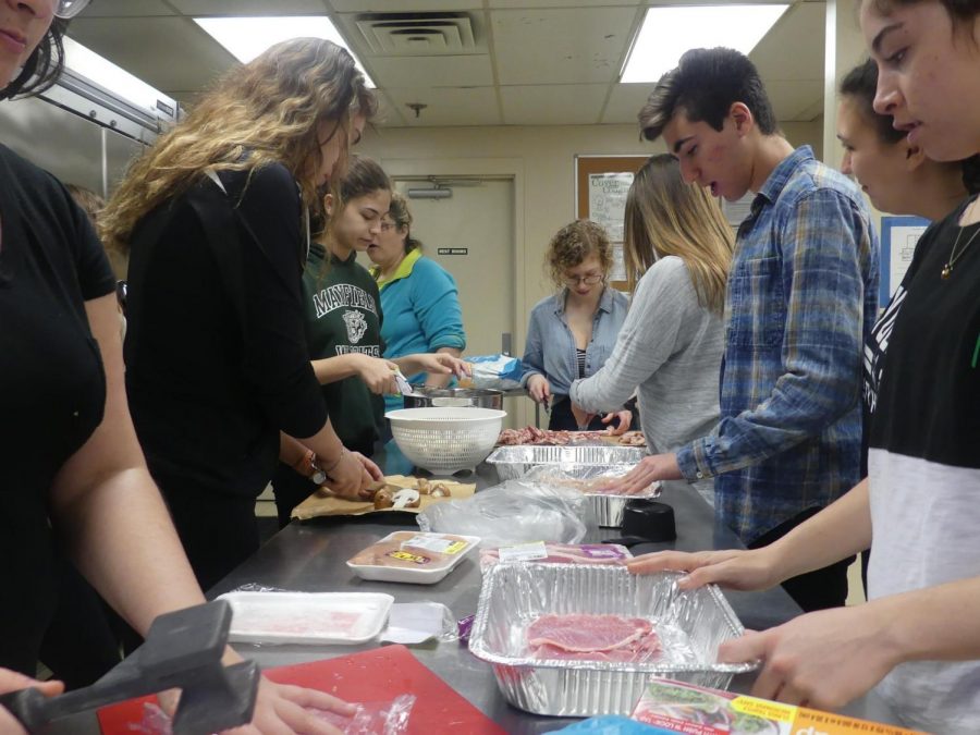 The club members make chicken cutlets at the annual dinner.
