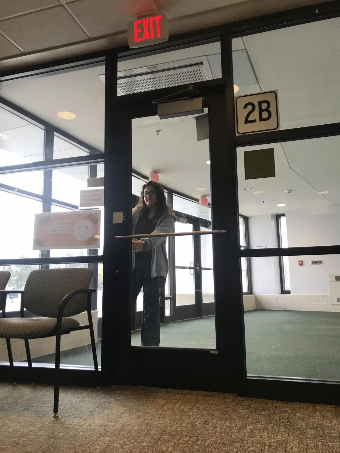 Junior Brianna Melarango waits in the vestibule to be buzzed into the school by a building secretary. There is talk to possibly move the vestibule outside of the school to improve school safety.