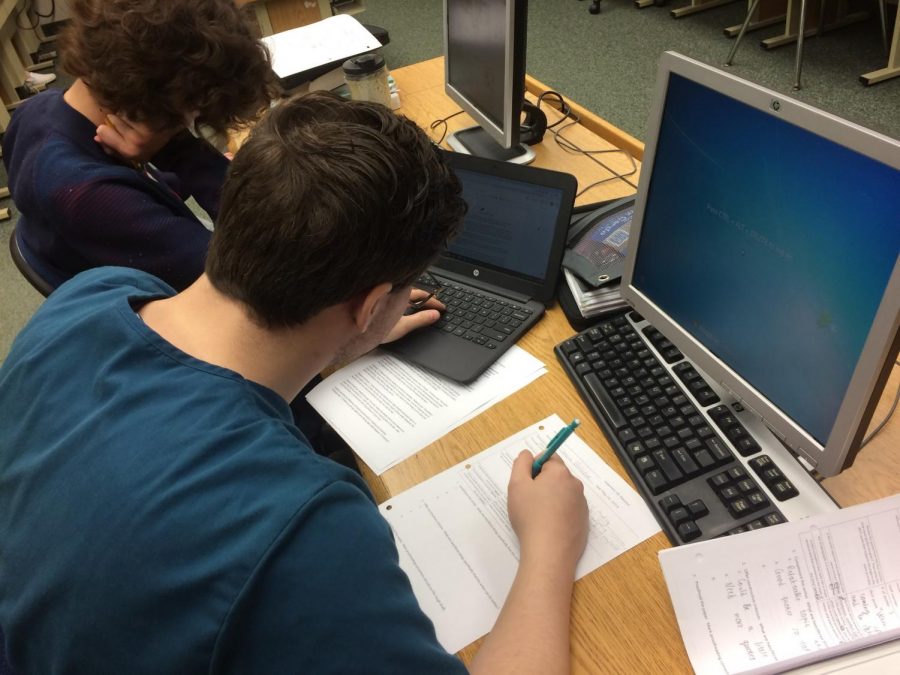 Because of the computer labs that are still available, junior Cameron Bluffstone has the luxury of working on his Chromebook and on a PC to complete his work.