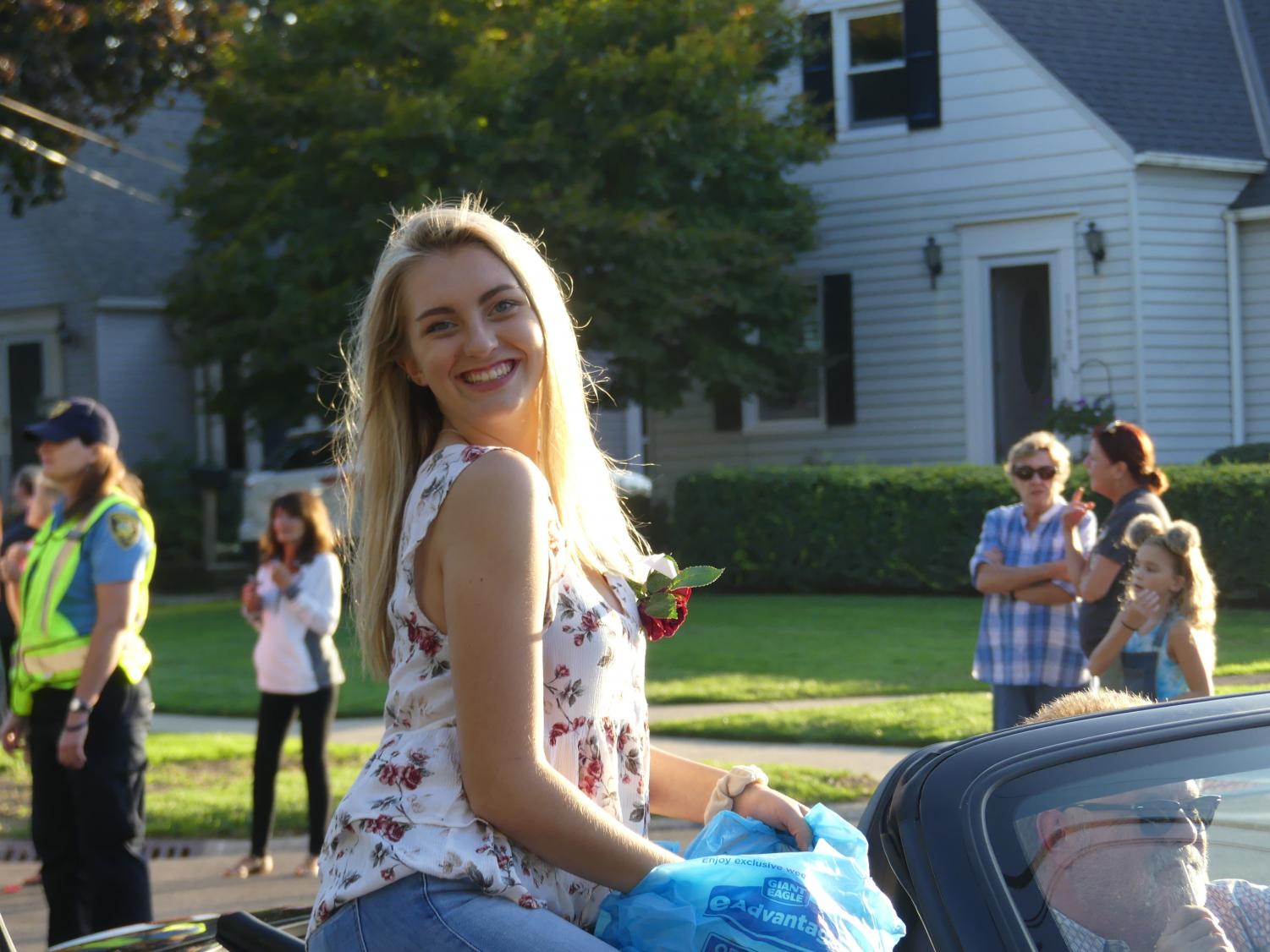 Jenna Hays, one of the 16 finalists to be Homecoming Queen, rides in a convertible during Wednesday's parade.