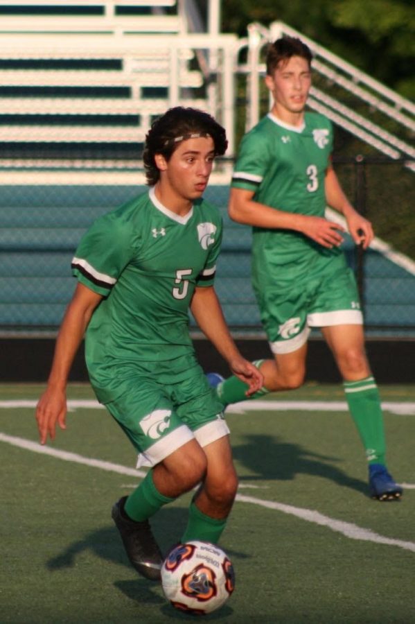 Senior Anthony DiTomas looks to take it to the goal as captain Henry Pernsteiner looks on. 