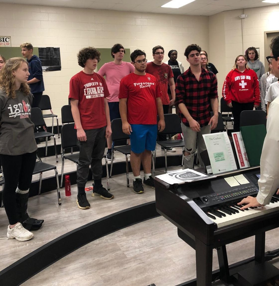Brian Fancher, bottom right, plays the piano and helps his students warm up for rehearsal. The Limited Edition show choir performs for the first time on Oct. 16.