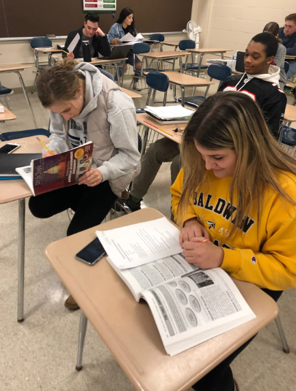 Seniors Breanna Veverka (left) and Gabby Tartaglia (right) use their government review books to prepare for the AIR test in Kris Kornblut’s class.