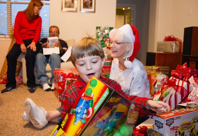 A family celebrates Christmas with the tradition of opening presents together. 