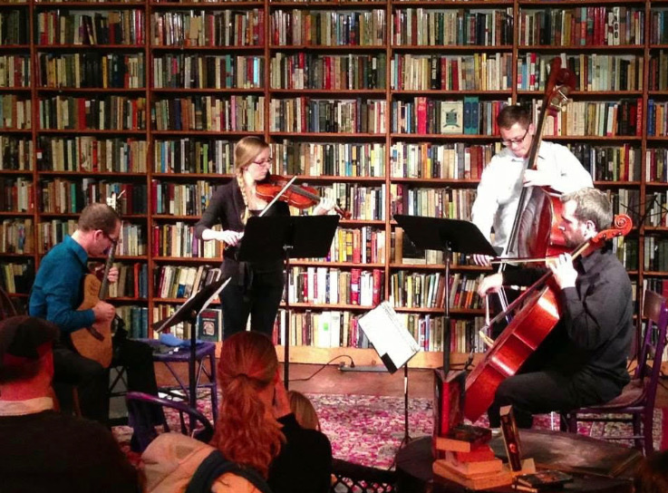 Joel Negus (standing on right) performs at the Tome Canvas Concert at Loganberry Books in Larchmere. 