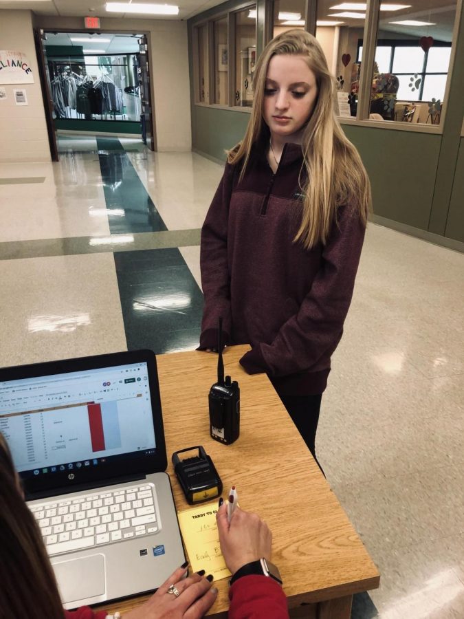 Junior Emily Byrne angrily waits at the tardy table to receive a yellow tardy pass.