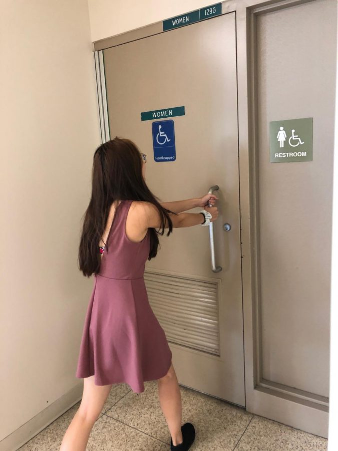 Senior Heidi Ngo struggles to open the door to the locked bathroom by the cafeteria, leaving only two available restrooms on the first floor.