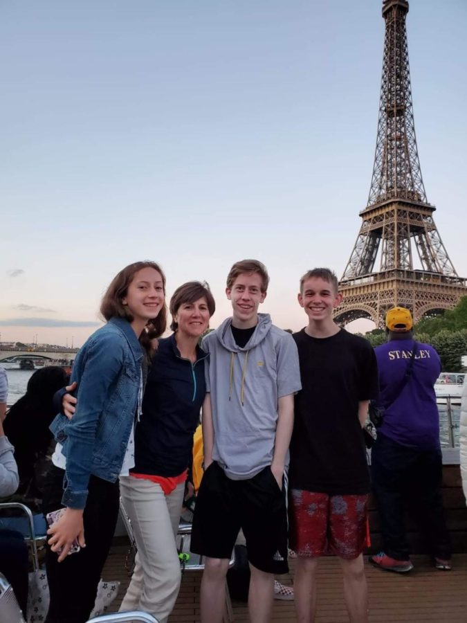 French Louise Vouk, second from the left, visits the Eiffel Tower with a group of students. 