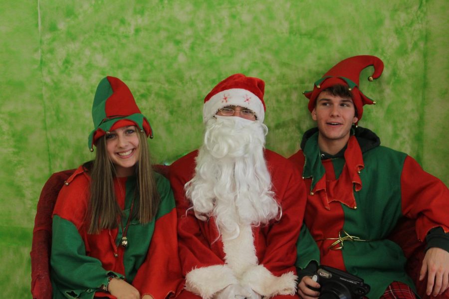 At last years Breakfast with Santa, Class of 2022 senior elves Nadia Gerbasi (left) and Jack Dominish (right) accompany Santa. This year, senior Lex Schneier will be dressing as Santa Claus.