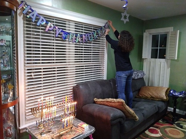 Senior Alena Murdakhaev helps her family decorate their living room for the holiday.