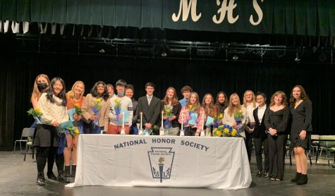 The NHS seniors surround the five pillar candles of the prestigious organization.  At last Fridays induction ceremony, the organization welcomed over 40 new members.