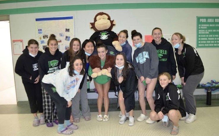 After a swim practice, the girls team gathers with their teams mascot.