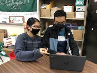 Science National Honors Society club officers Jenny Sarkar (left) and Mohammad Zoraiz (right) look over event ideas that Zoraiz suggests.