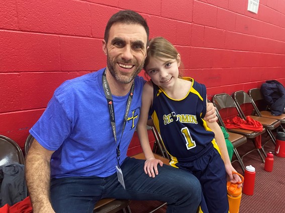 At a St. Dominics basketball game, head coach Michael Verdi meets with his daughter Annabelle on the bench.