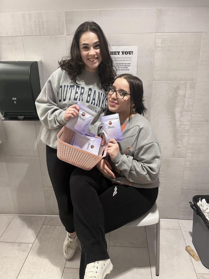 Seniors Joanna Sikoutris (left) and Kenza Mahdaoui (right) show the different feminine products accessible in all of the high school’s bathrooms. Sikoutris and Mahdaoui completed research until they found their capstone project idea. Sikoutris said, “Kenza showed me an Instagram post from another high school that did this type of project, and I knew that we had to do something like this at Mayfield.”