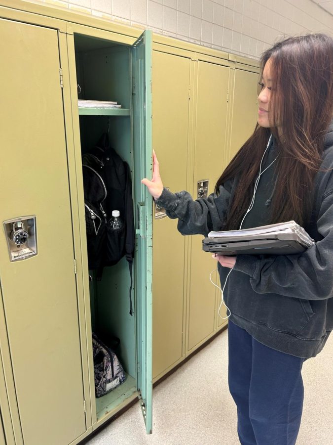 Sophomore Emma Tisch demonstrates how she will carry her books and keep her backpack in her locker next year. 